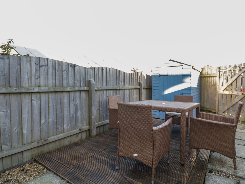 A garden with a table and chairs and a shed at Seahorses in Padstow