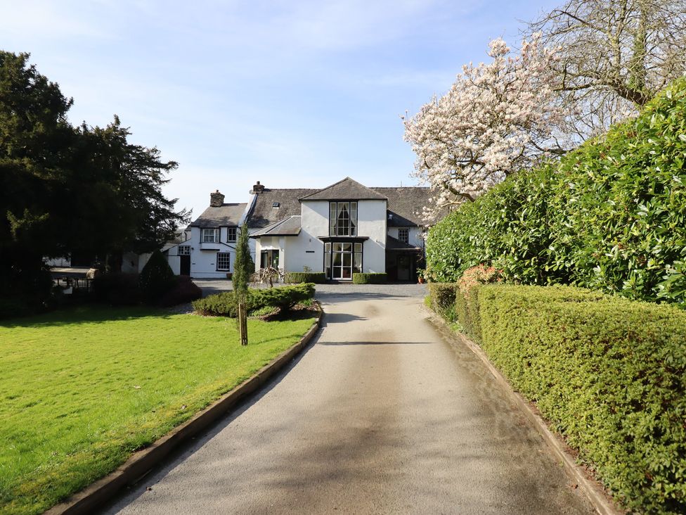 A house with a driveway and landscaping at Plas Dolguog in Machynlleth