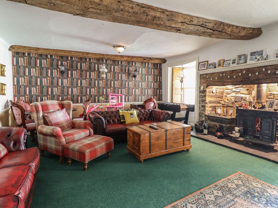 A living room with sofas, a coffee table, and a fireplace at Plas Dolguog in Machynlleth