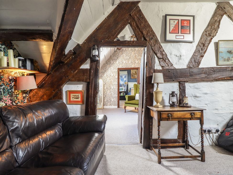 A living room with a leather sofa and a wooden table at Plas Dolguog in Machynlleth