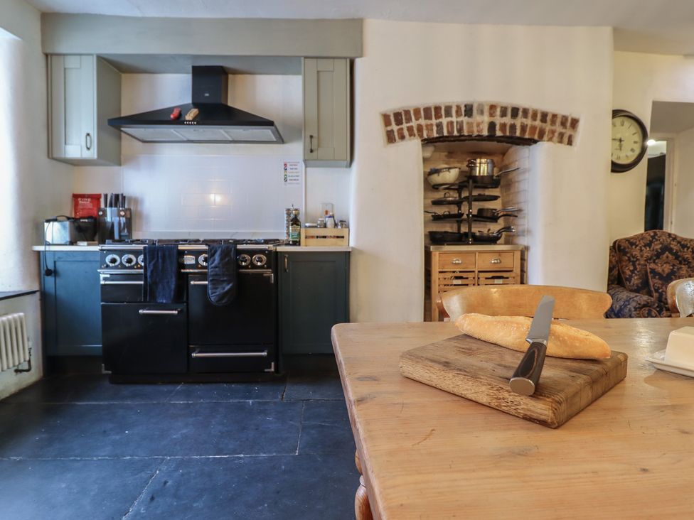 A kitchen with oven, cutting board, and bread at Plas Dolguog in Machynlleth