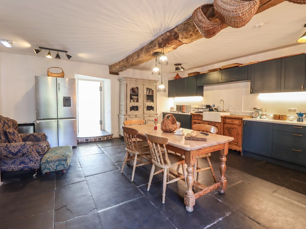 A kitchen with a table and chairs at Plas Dolguog in Machynlleth