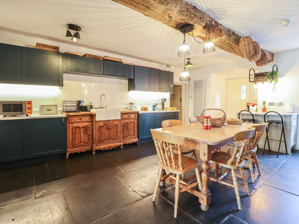 A kitchen with a dining table and chairs at Plas Dolguog in Machynlleth