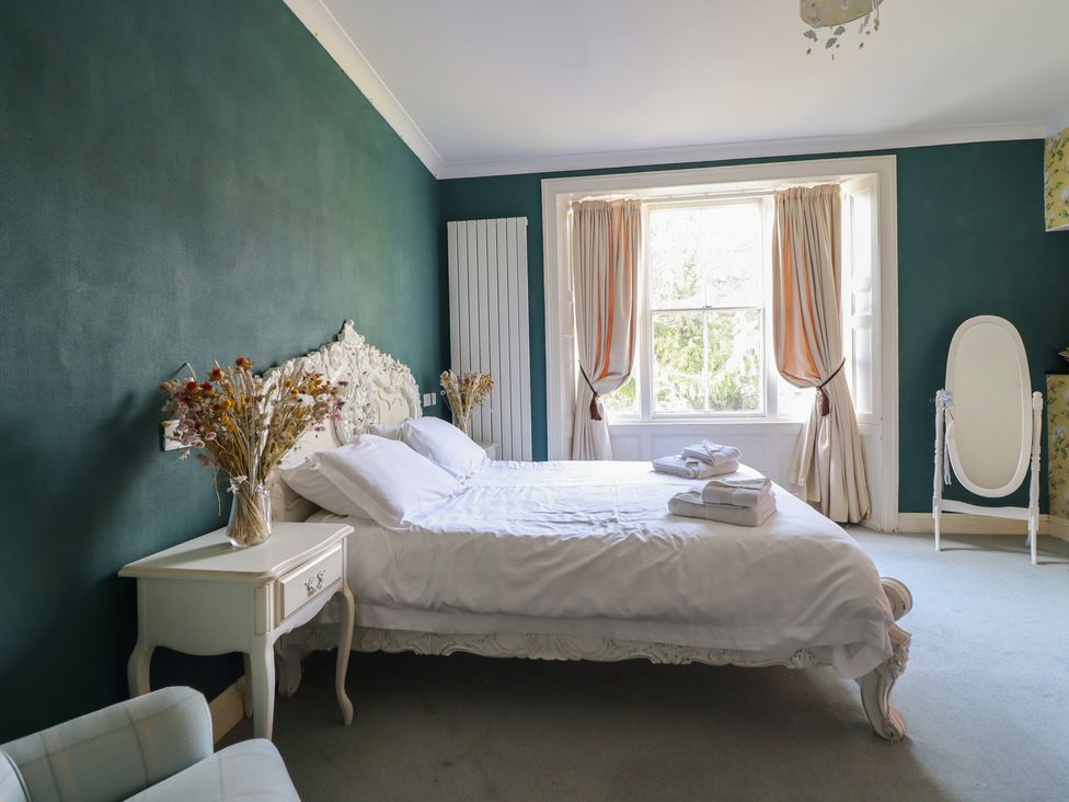 A bedroom with a bed and window at Plas Dolguog in Machynlleth