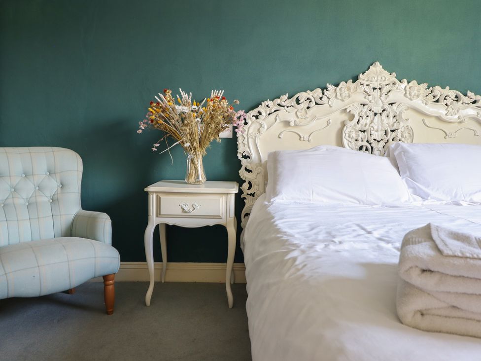 A bedroom with a bed and a bedside table at Plas Dolguog in Machynlleth