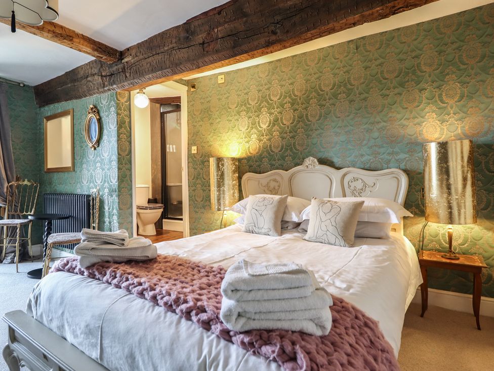 A bedroom with a bed and an ensuite bathroom at Plas Dolguog in Machynlleth