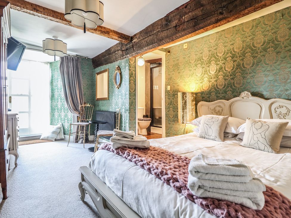 A bedroom with a bed and a television at Plas Dolguog in Machynlleth