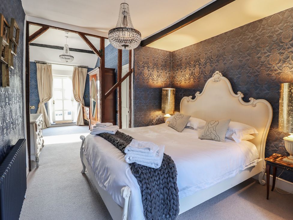 A bedroom with a bed and curtains at Plas Dolguog in Machynlleth