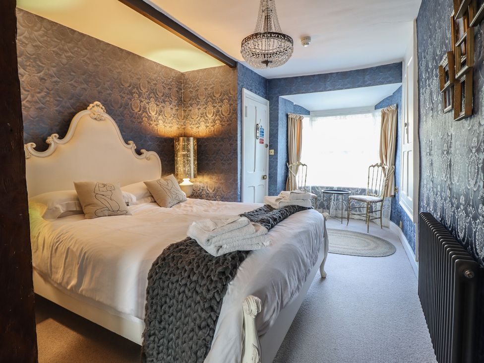 A bedroom with a bed and seating area at Plas Dolguog in Machynlleth