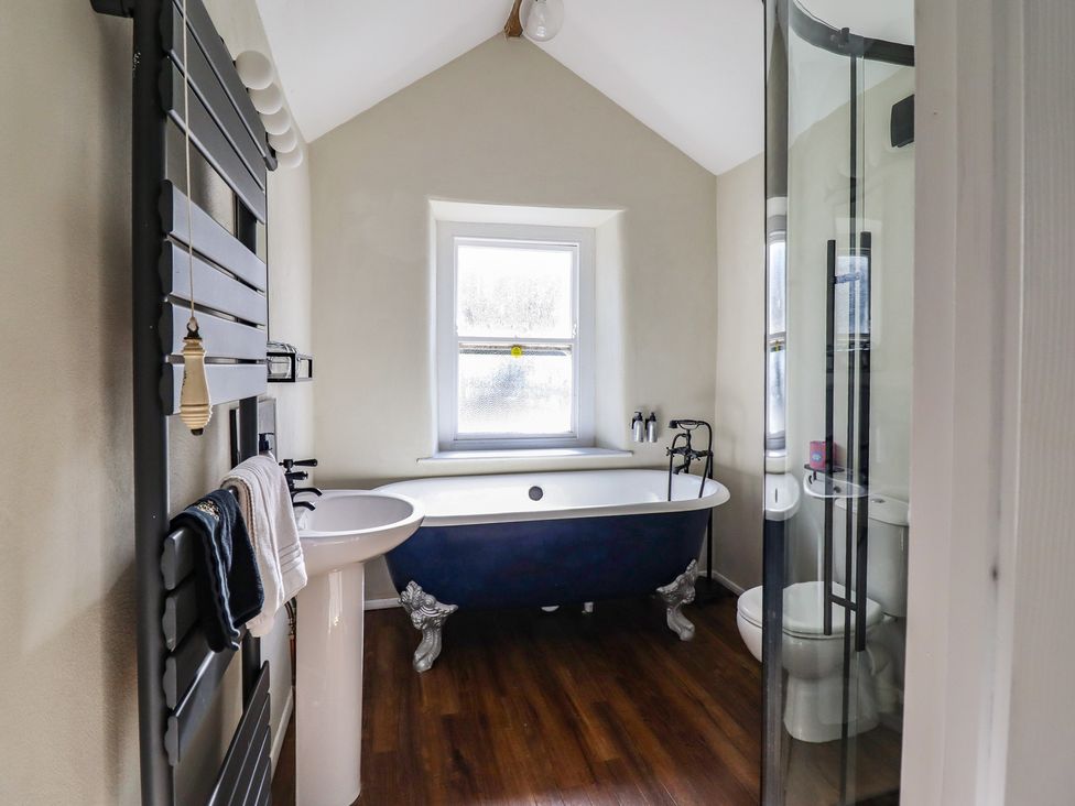 A bathroom with a bathtub and sink at Plas Dolguog in Machynlleth