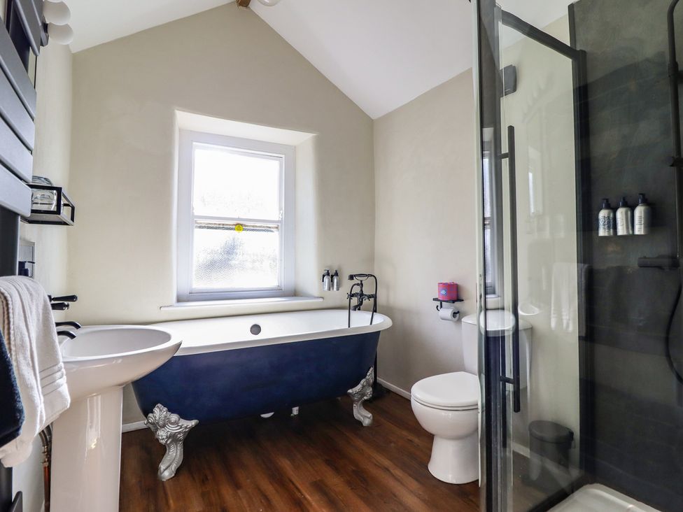 A bathroom with a bathtub and sink at Plas Dolguog in Machynlleth