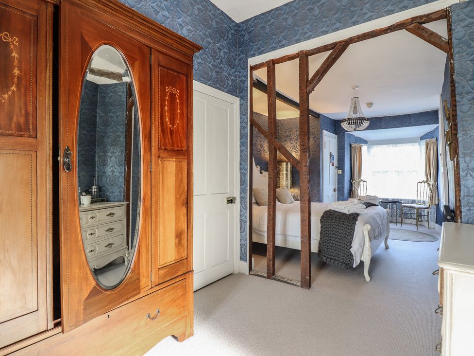 A bedroom with a wardrobe and bed at Plas Dolguog in Machynlleth
