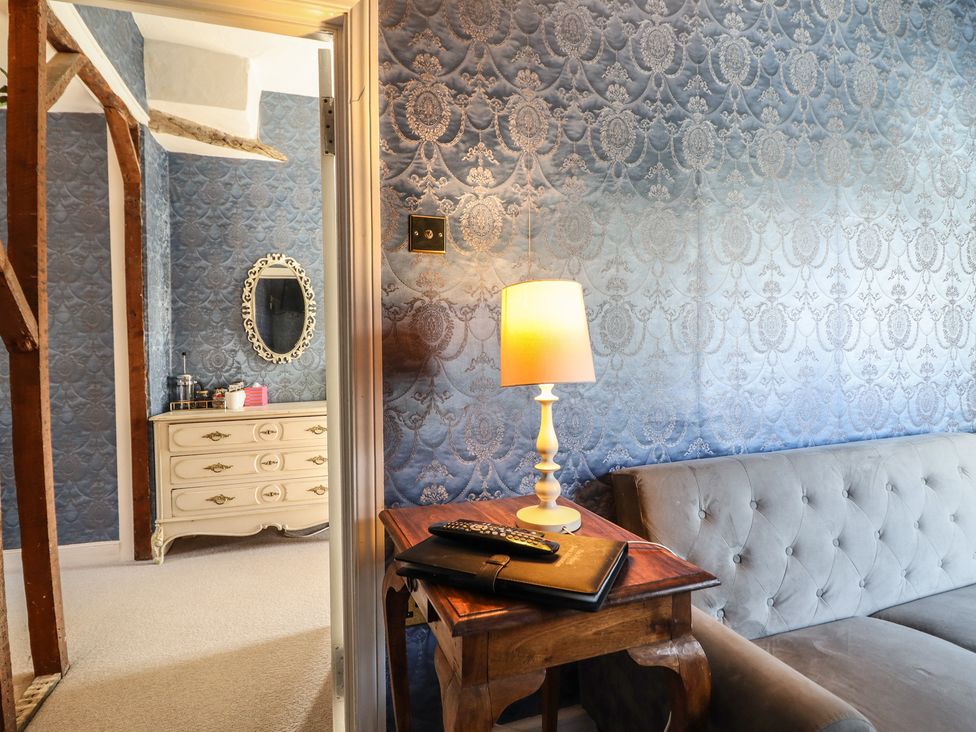 A bedroom with a sofa and a lamp at Plas Dolguog in Machynlleth