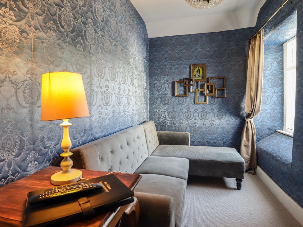 A living room with a sofa and lamp at Plas Dolguog in Machynlleth