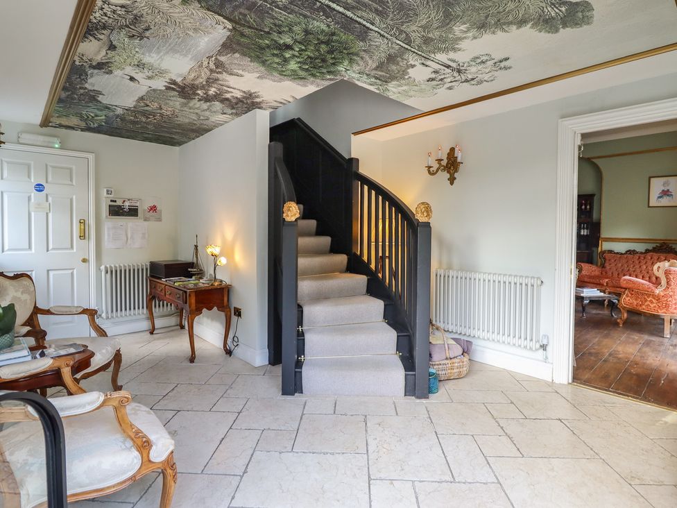 An entrance hall with a staircase leading up at Plas Dolguog in Machynlleth