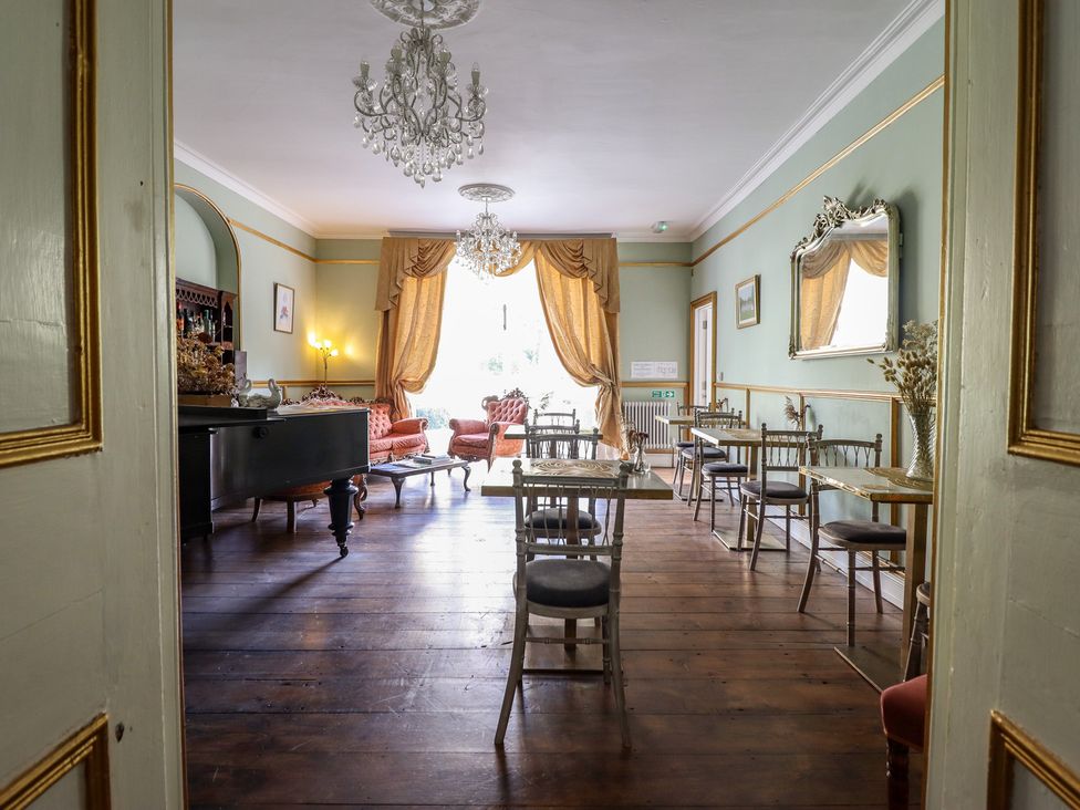 A dining room with tables and chairs at Plas Dolguog in Machynlleth