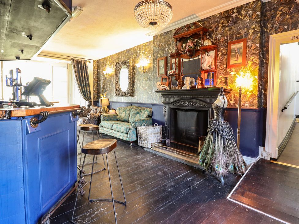 A living room with a bar and sofa at Plas Dolguog in Machynlleth