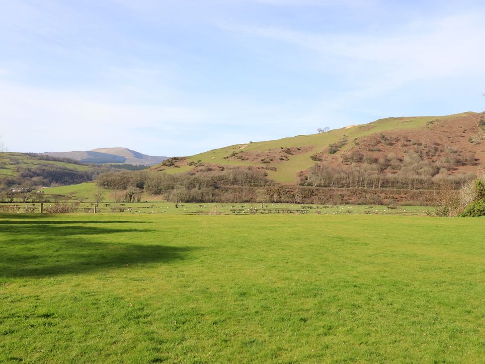 A landscape with hills and grass at Plas Dolguog in Machynlleth