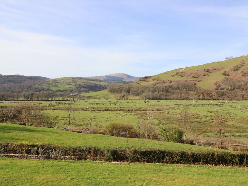 A landscape view with hills and fields at Plas Dolguog in Machynlleth