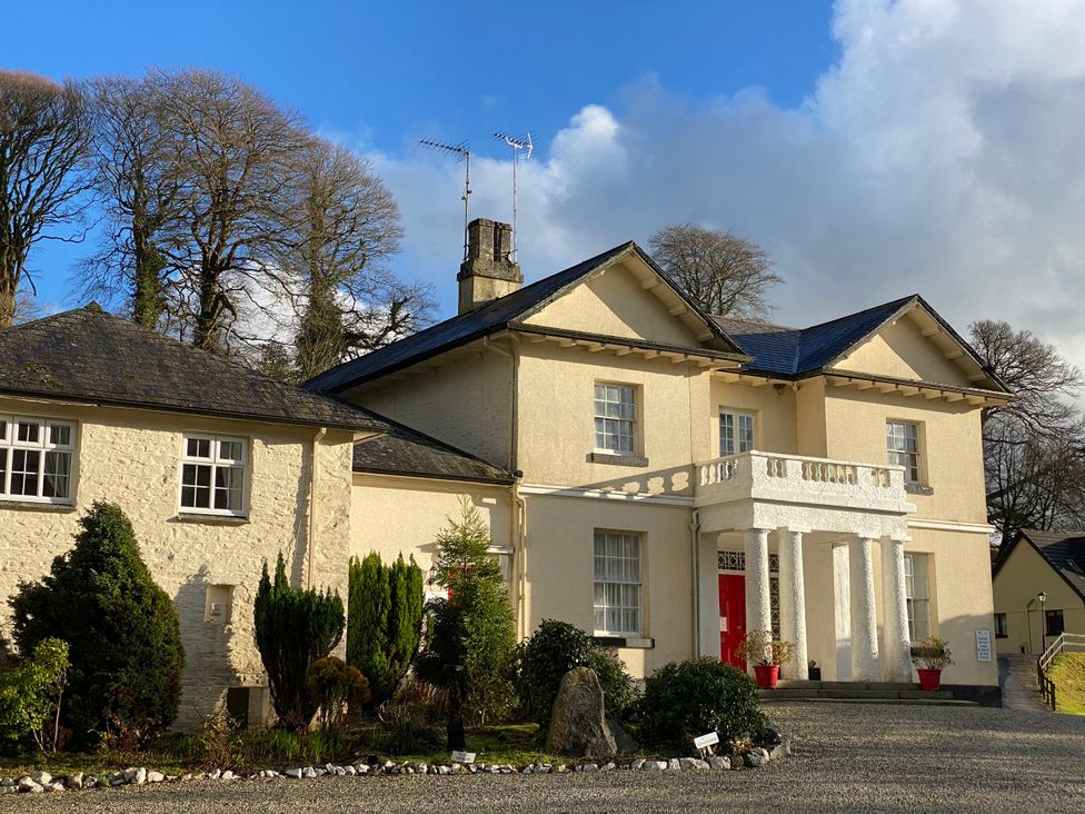 A house with a red door and trees at Lakeview Villa near Liskeard