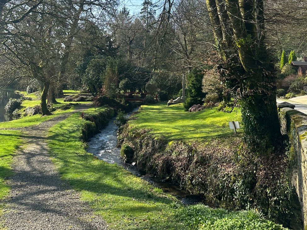 A path alongside a stream and trees at Lakeview Villa near Liskeard