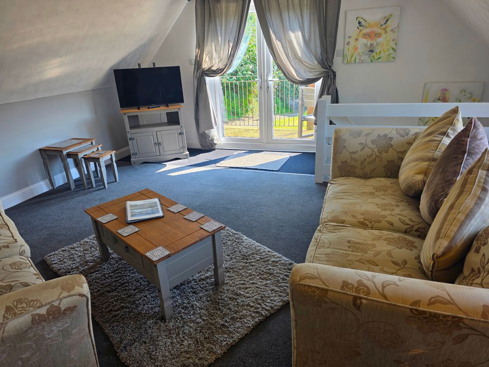 A living room with a television and coffee table at Lakeview Villa near Liskeard
