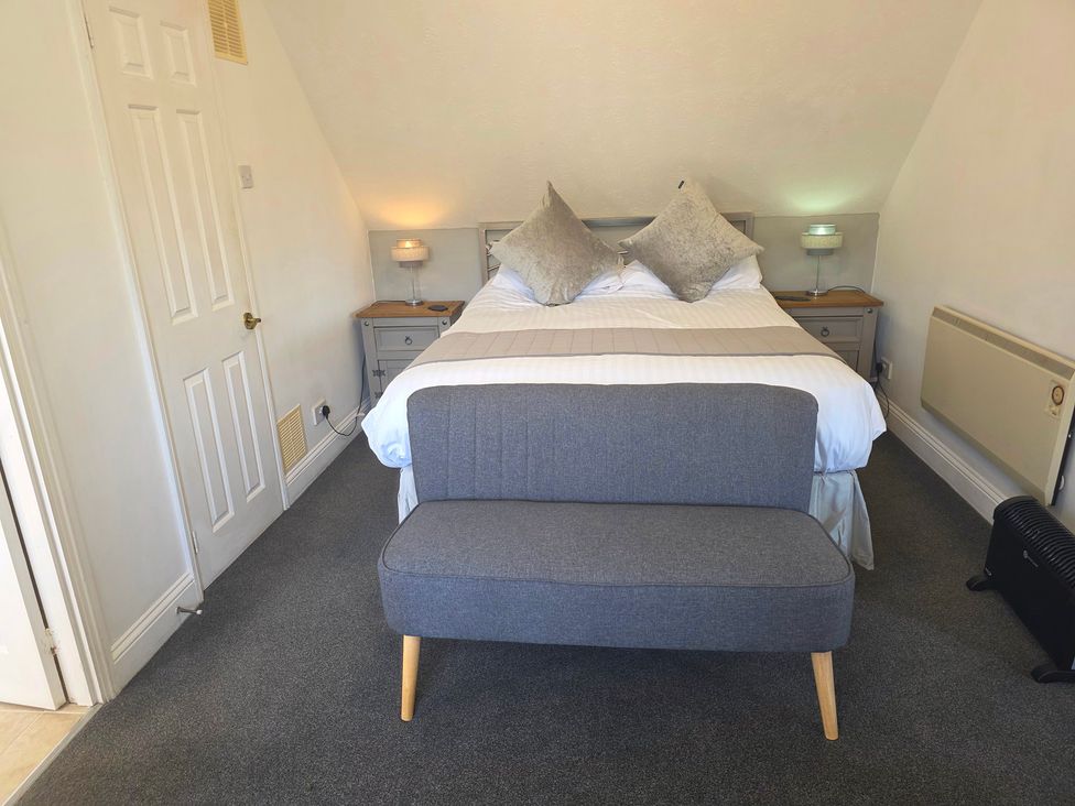 A bedroom with a bed and nightstands at Lakeview Villa near Liskeard