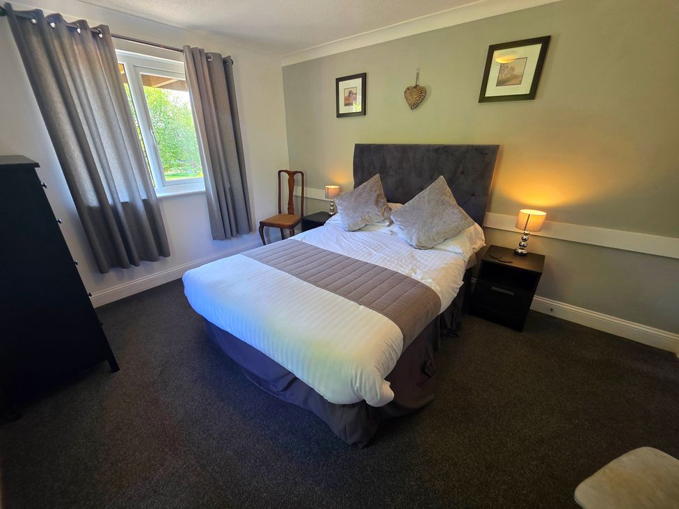 A bedroom with a double bed and bedside table at Lakeview Villa near Liskeard