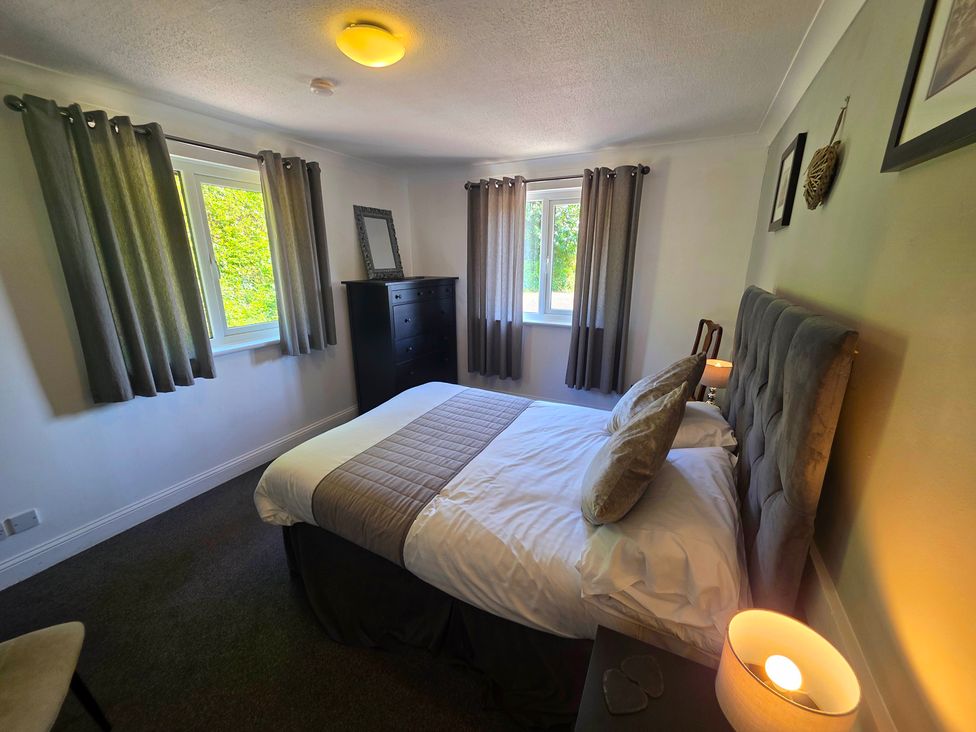 A bedroom with a bed and a chest of drawers at Lakeview Villa near Liskeard