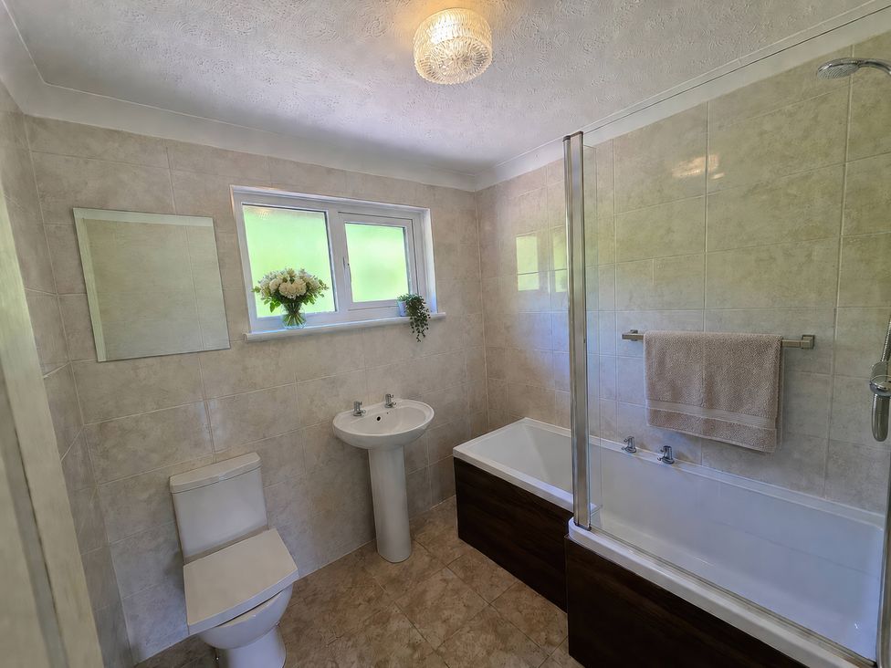 A bathroom with a toilet, sink, and bathtub at Lakeview Villa near Liskeard