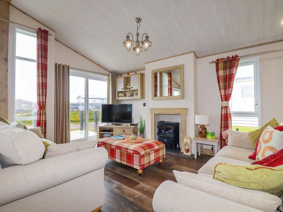A living room with a TV and a fireplace at 8 Summerleaze in Bude