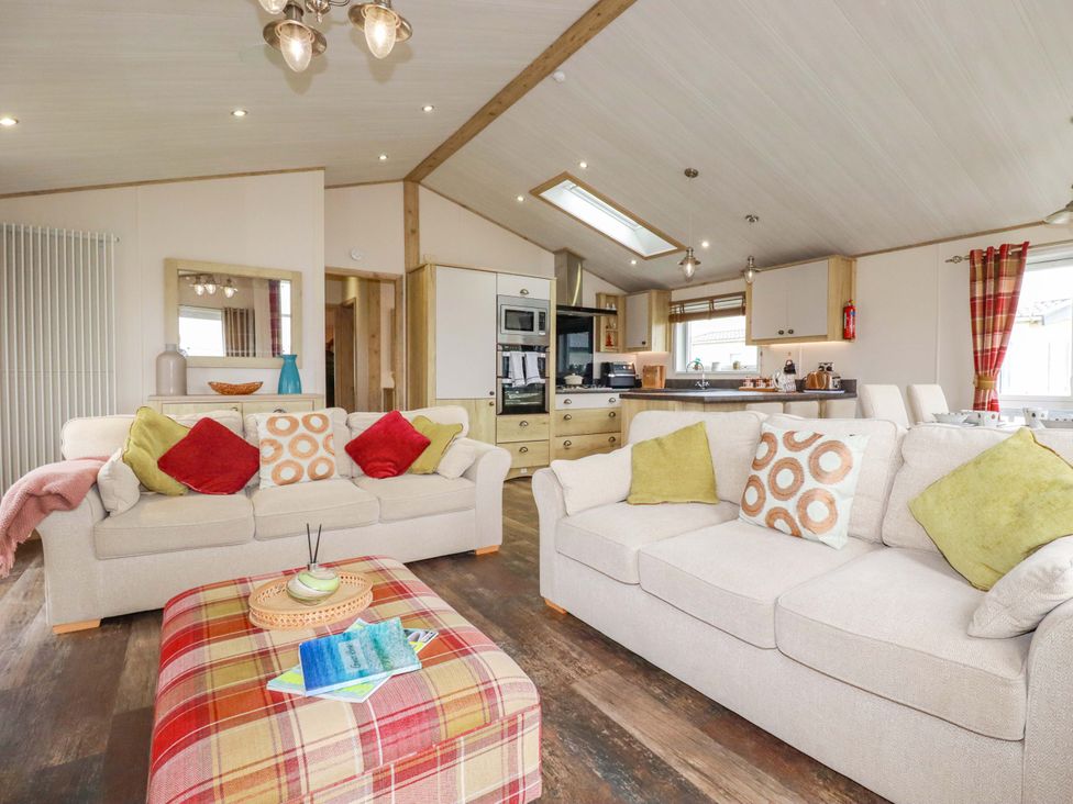 A living room with sofas and a table at 8 Summerleaze in Bude