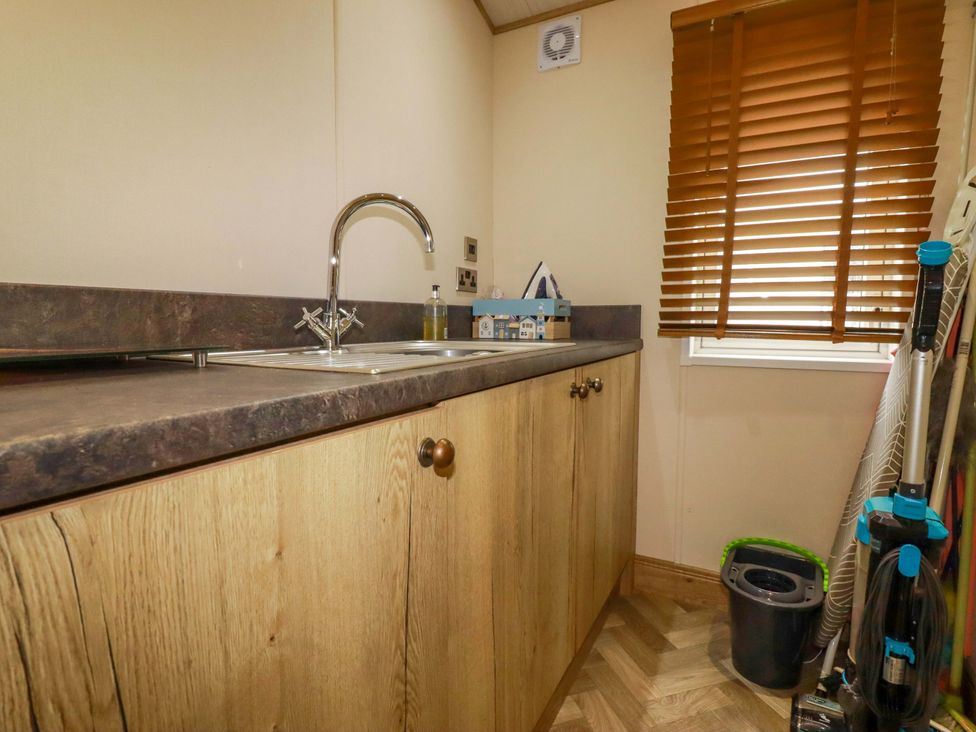 A laundry room with a sink and cupboards at 8 Summerleaze in Bude