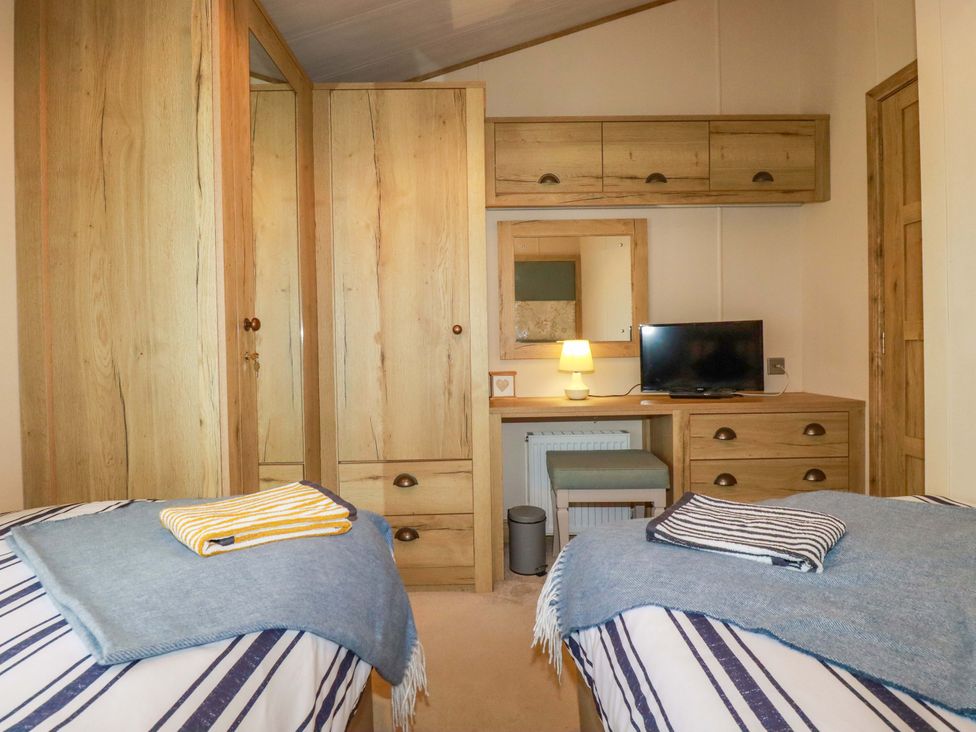 A bedroom with two beds and a desk at 8 Summerleaze in Bude