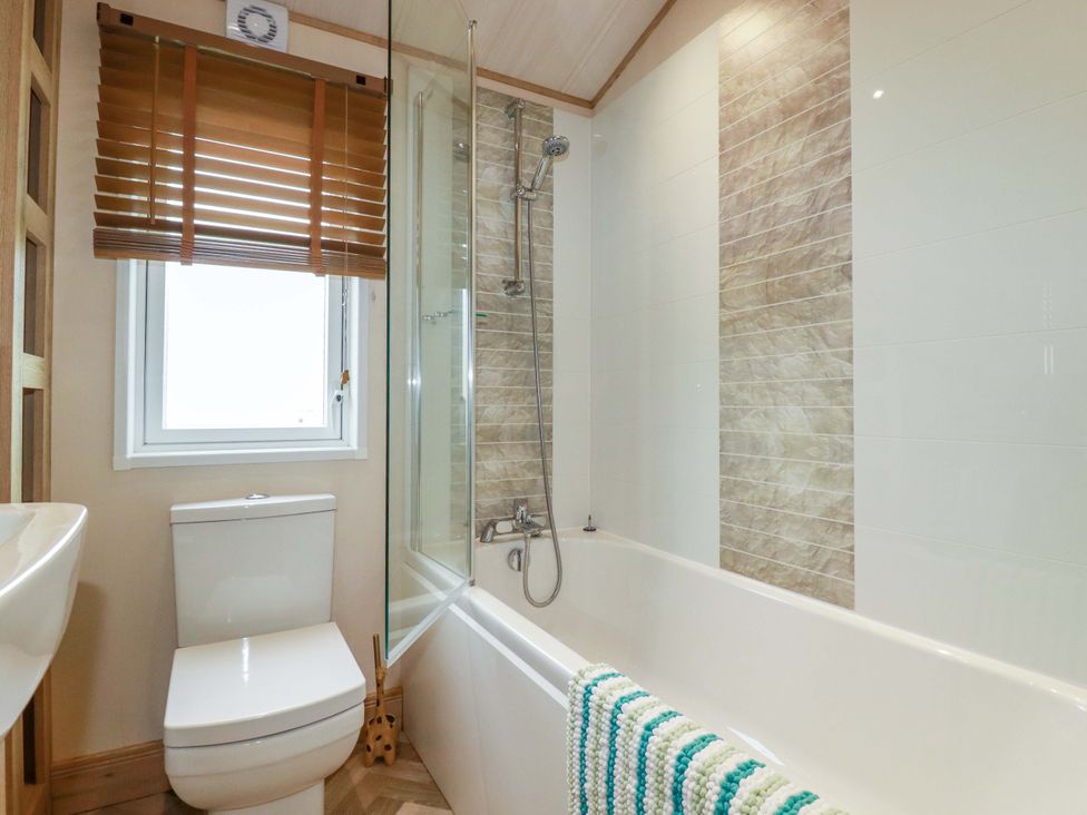 A bathroom featuring a toilet, shower, and bathtub at 8 Summerleaze in Bude