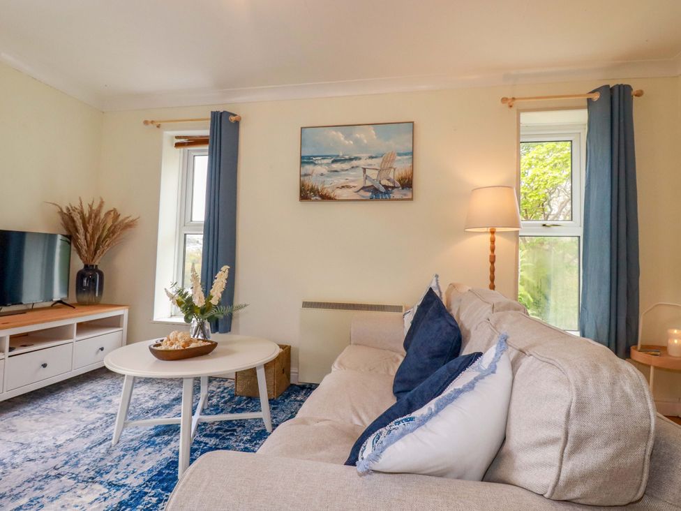 A living room with a sofa and television at Flat 5 in Looe
