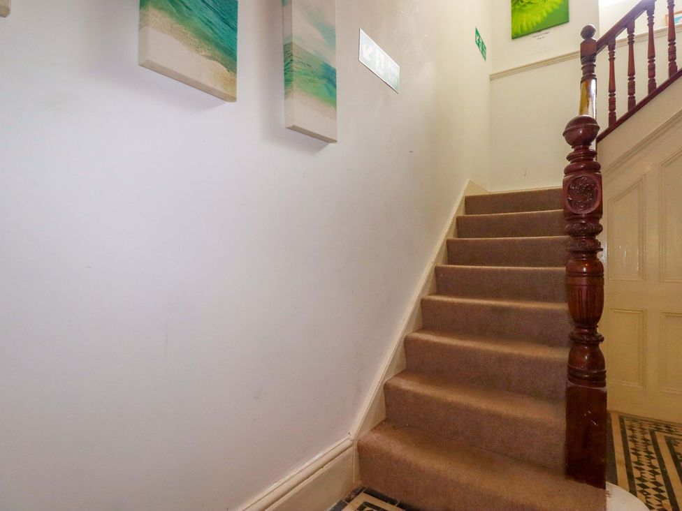 A staircase with carpet and wall paintings at Flat 5 in Looe