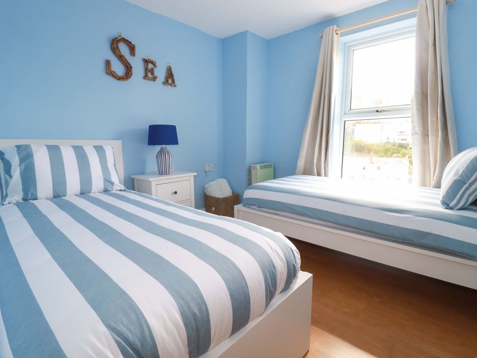 A bedroom with two beds and a lamp at Flat 5 in Looe