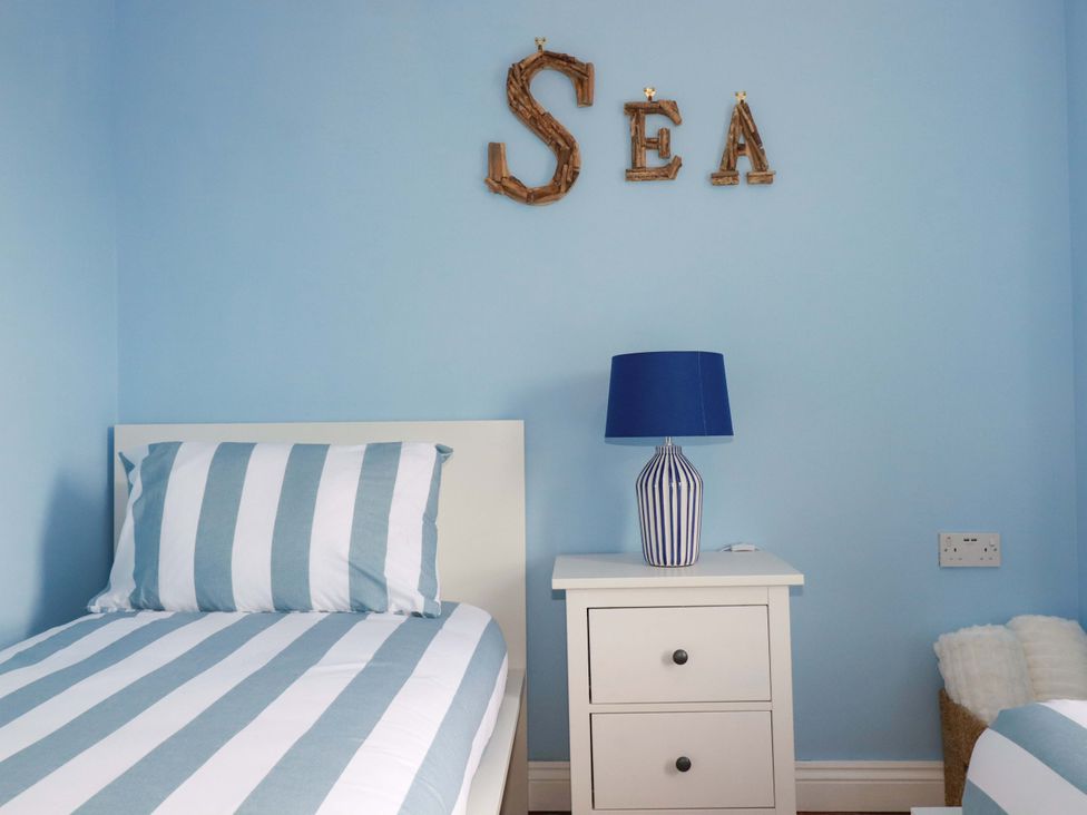 A bedroom with two single beds and a lamp at Flat 5 in Looe