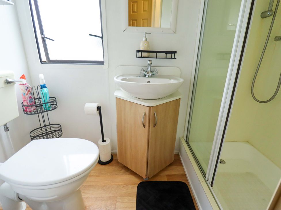 A bathroom featuring a toilet, wash basin, and shower at Southview Leisure Park - Firs 83, Skegness