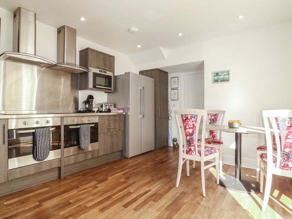 A kitchen with appliances and dining area at Sea View in Newquay