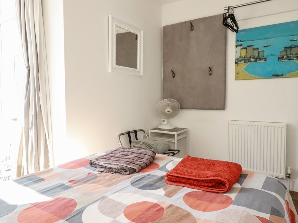 A bedroom with a bed and towels at Sea View in Newquay