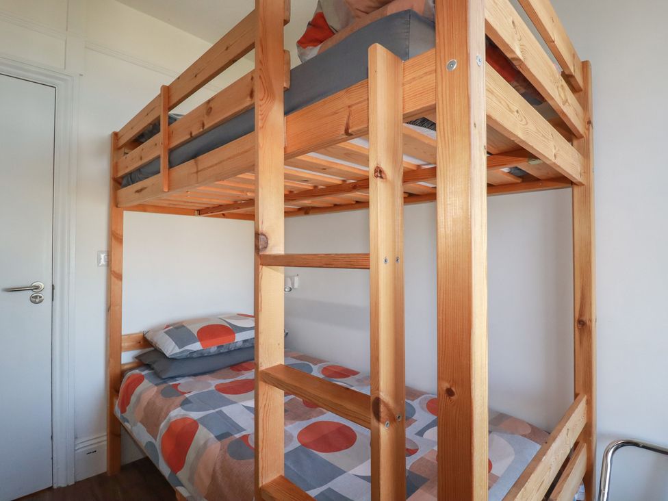 A bunk bed with bedding and a door in the bedroom at Sea View in Newquay