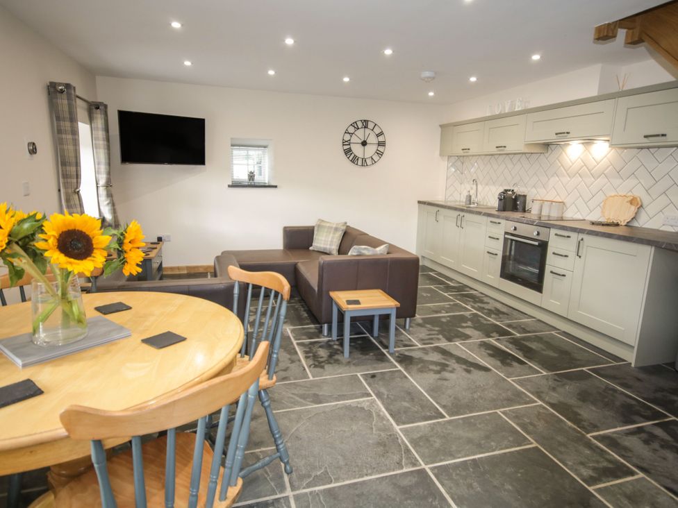 A kitchen with a dining area and sofa at Sun Trevor Barn 1 Llangollen