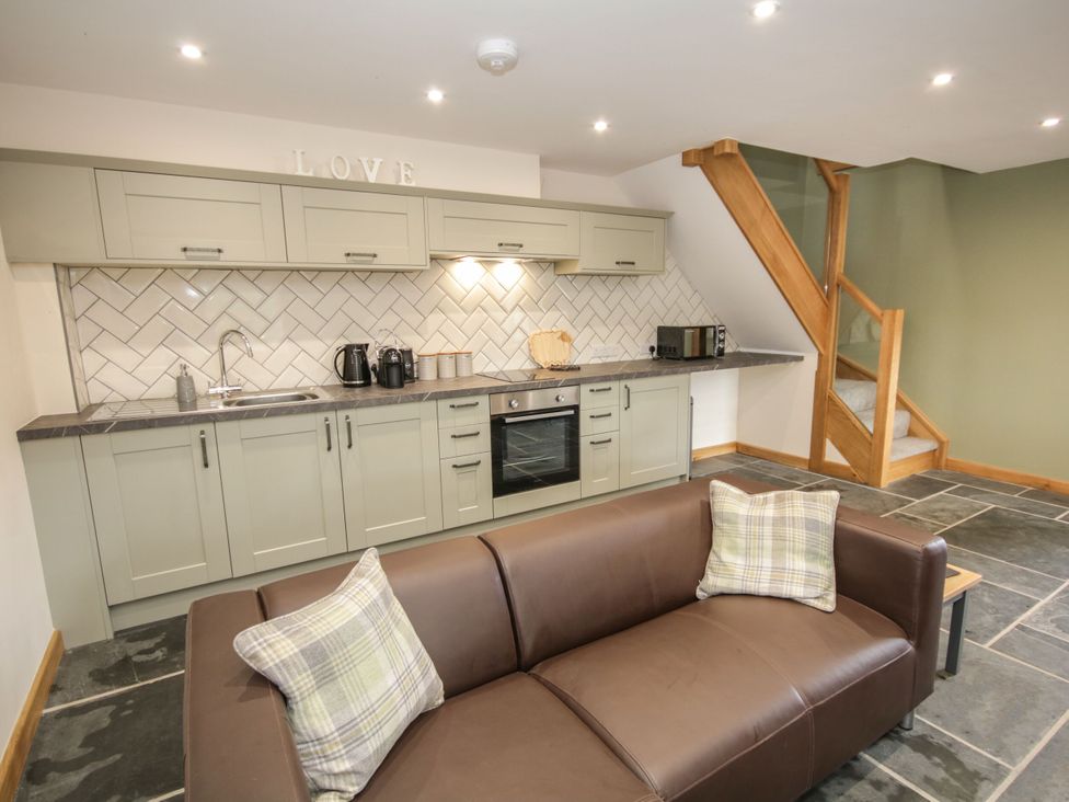 A kitchen with a sofa and appliances at Sun Trevor Barn 1 Llangollen