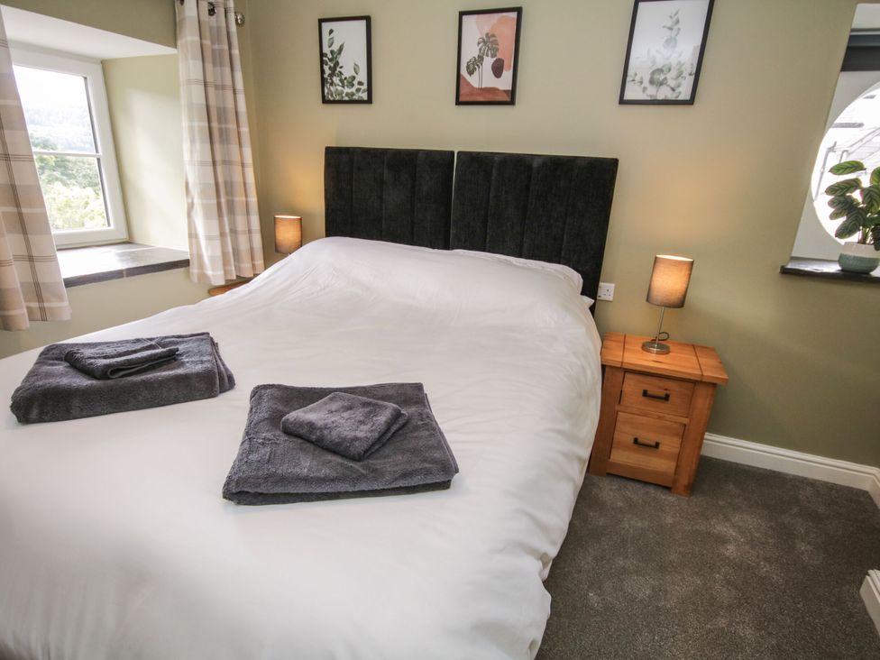 A bedroom with a bed and bedside table at Sun Trevor Barn 1 Llangollen