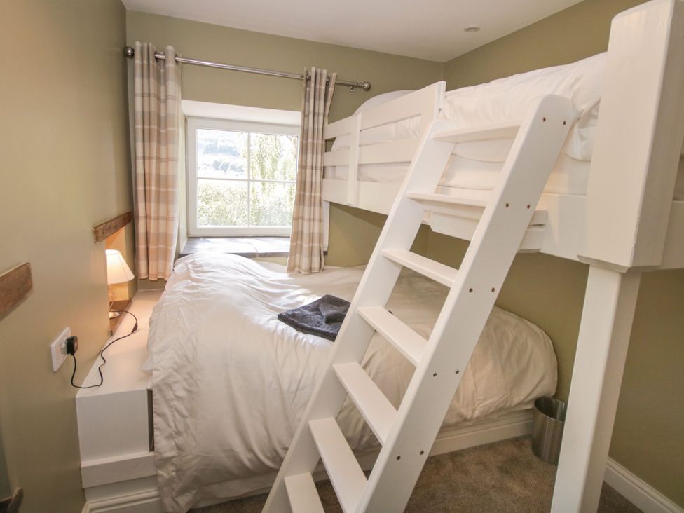 A bedroom with a bunk bed and a window at Sun Trevor Barn 1, Llangollen