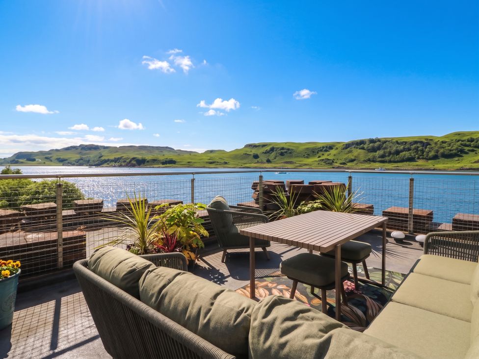 A deck with a table and chairs overlooking water at Heather Island View