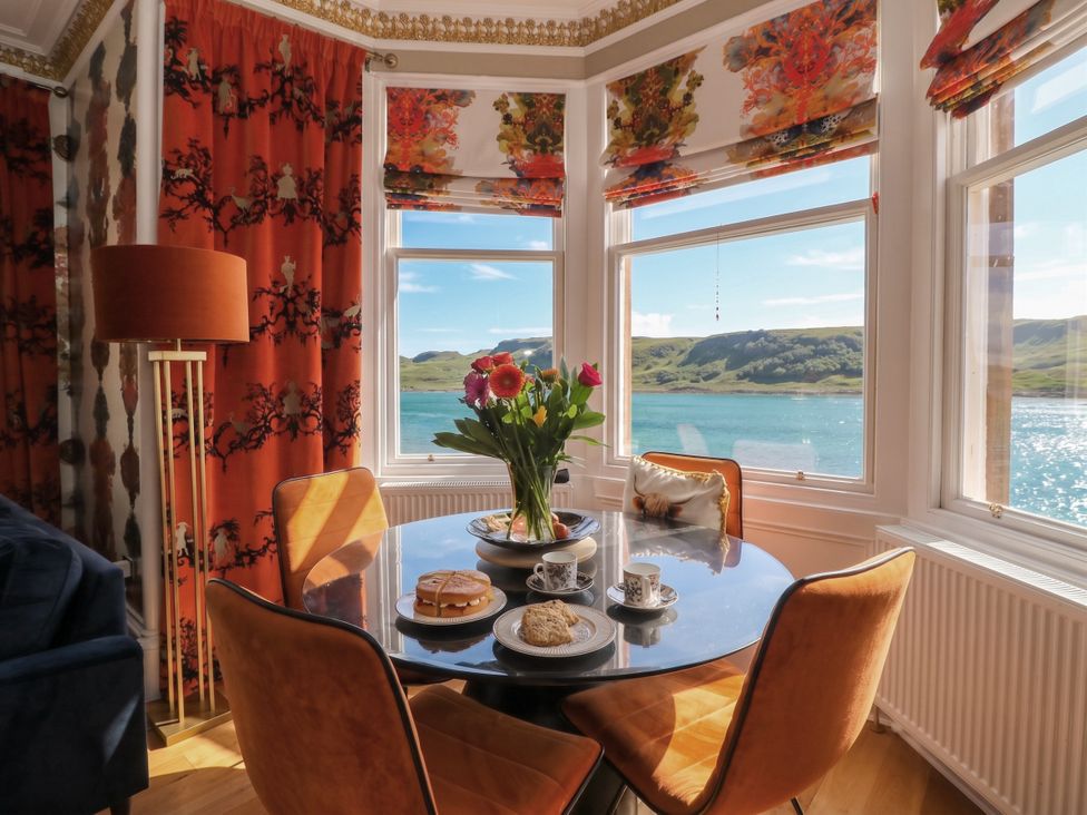 A dining room with a table and flowers at Heather Island View 