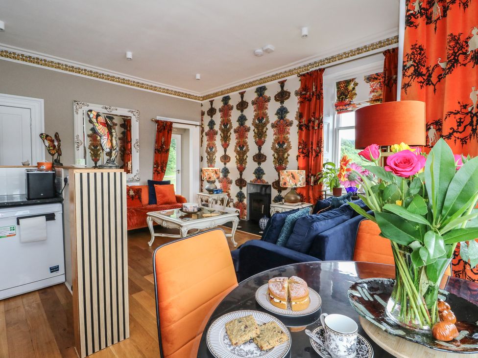 A living room with a sofa, coffee table, and flowers at Heather Island View